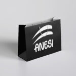 Black shopping bag with a white logo and rope handles displayed on a light gray background.